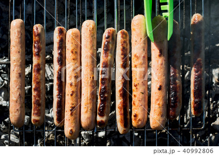 Spicy sausages grilling on barbecue on picnic.  40992806
