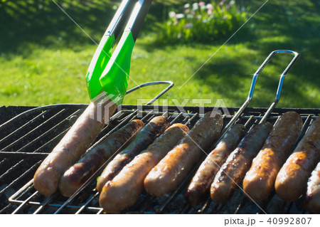 Sausages grilling on barbecue on summer picnic. Sausages grilling on barbecue on summer picnic. 40992807