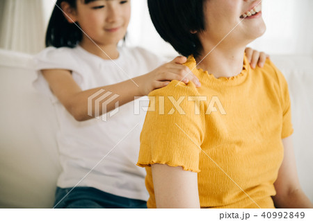 母親の肩を揉む小学生の女の子の写真素材 40992849 Pixta