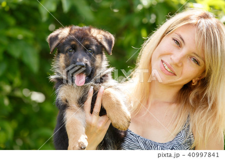 Young smiling woman with puppy of german shepherd Young smiling woman with puppy of german shepherd 40997841