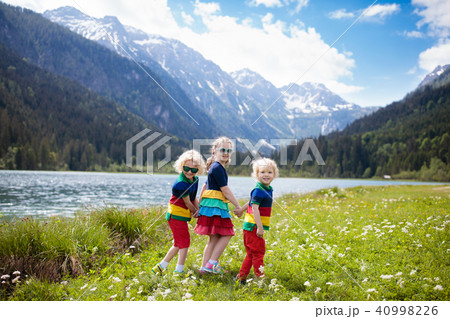 Children hiking in flower field at mountain lake 40998226