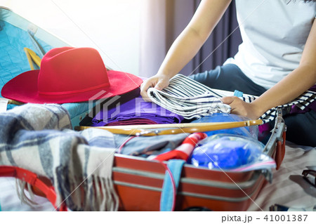 Travel and vacation concept, happiness woman packing stuff and a 41001387