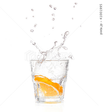 orange splashing into glass of water on white orange splashing into glass of water on white 41001995