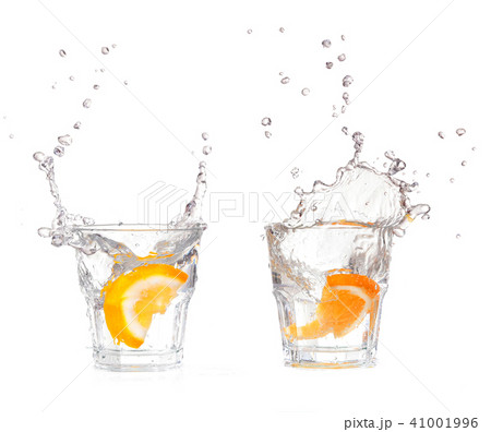 orange splashing into glass of water on white orange splashing into glass of water on white 41001996