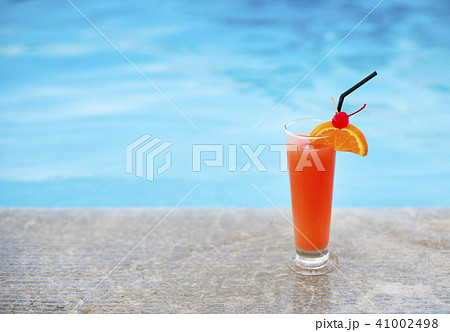 Glass of tropical cocktail on poolside 41002498