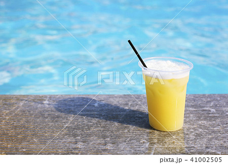 Glass of tropical cocktail on poolside 41002505