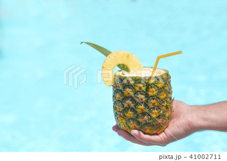 Exotic pineapple cocktail near pool. Pina colada 41002711