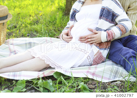 Happy pregnant couple in the blossom garden 41002797