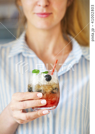 Woman holding blueberry cocktail with ice  41002803