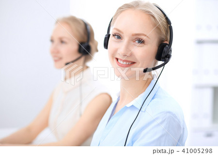 Bright  call center office. Two blonde women in a headset 41005298