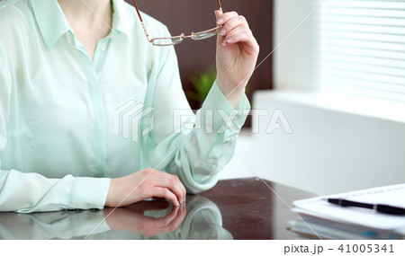 Business woman or secretary  sitting at the desk in the office. Green toned image 41005341