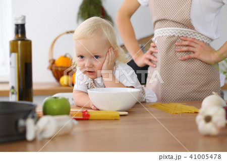 Mother and little daughter  cooking in the kitchen. Spending time all together or happy famil 41005478