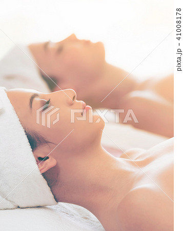 Relaxed young woman lying on spa bed for massage. Relaxed young woman lying on spa bed for massage. 41008178