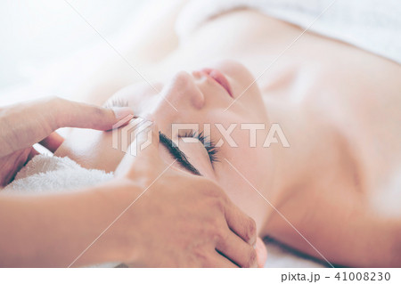 Woman gets facial and head massage in luxury spa. Woman gets facial and head massage in luxury spa. 41008230
