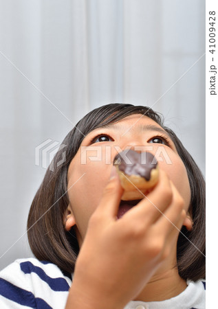 エクレアを美味しそうに食べる女の子 エクレアを美味しそうに食べる女の子 41009428
