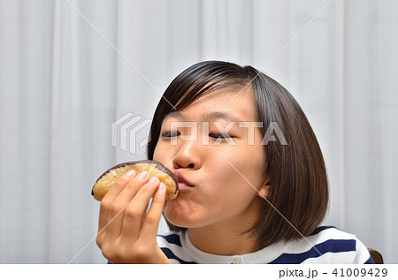 エクレアを美味しそうに食べる女の子 エクレアを美味しそうに食べる女の子 41009429