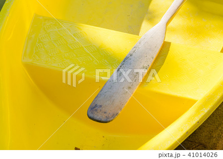 Wooden oar on yellow fiber rowboat in pond Wooden oar on yellow fiber rowboat in pond 41014026