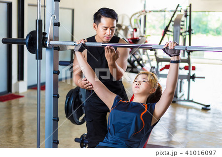 Young Asian woman working out with her trainer Young Asian woman working out with her trainer 41016097
