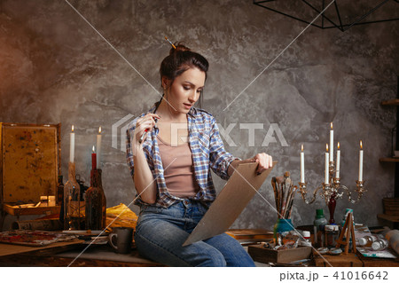 Good-looking cheerful professional young female artist working on new creative project, drawing Good-looking cheerful professional young female artist working on new creative project, drawing 41016642