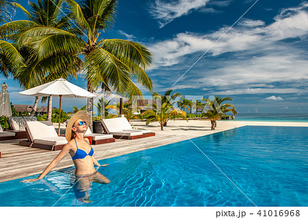 Woman with hat at beach pool in Maldives Woman with hat at beach pool in Maldives 41016968