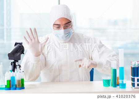Young chemist pressing virtual buttons in lab 41020376
