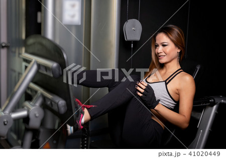 Sportive woman using weights press machine Sportive woman using weights press machine 41020449