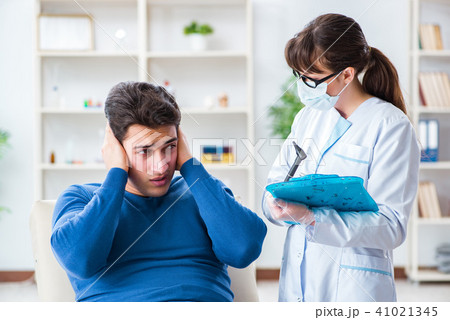Doctor checking patients ear during medical examination 41021345