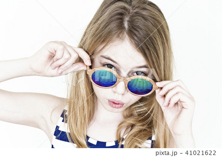 Cute girl in green sunglasses on white 41021622