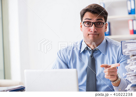 Extremely busy businessman working in office 41022238