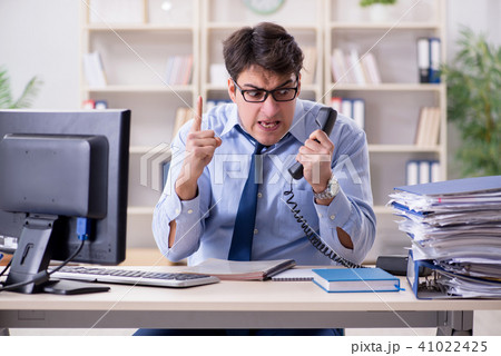 Businessman frustrated at many telephone calls 41022425