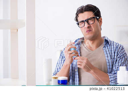 Young man is getting prepared for working day in bathroom Young man is getting prepared for working day in bathroom 41022513