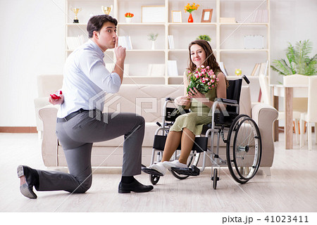 Man making marriage proposal to disabled woman on wheelchair 41023411