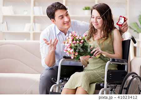Man making marriage proposal to disabled woman on wheelchair Man making marriage proposal to disabled woman on wheelchair 41023412