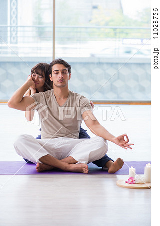 Personal coach helping during yoga session 41023756
