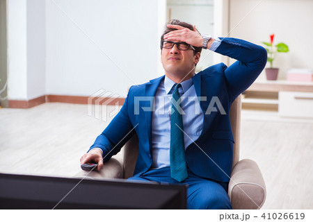 Businesman watching tv in office Businesman watching tv in office 41026619