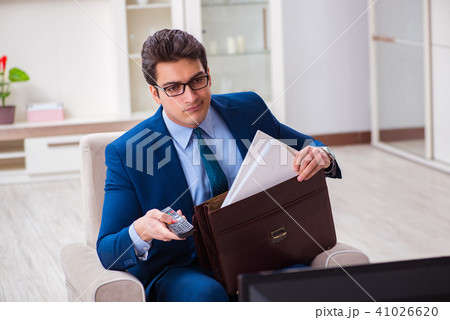 Businesman watching tv in office Businesman watching tv in office 41026620