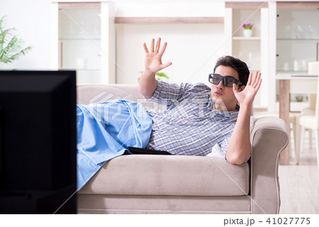 Man watching 3d tv at home Man watching 3d tv at home 41027775
