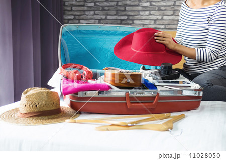 Travel and vacation concept, happiness young woman packing a lot Travel and vacation concept, happiness young woman packing a lot 41028050