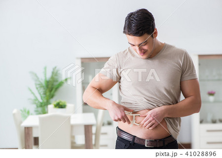 Man measuring body fat with calipers 41028896