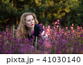 Young woman in a field with wild flowers. 41030140