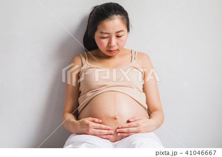 Asian pregnant women sitting on bed Asian pregnant women sitting on bed 41046667