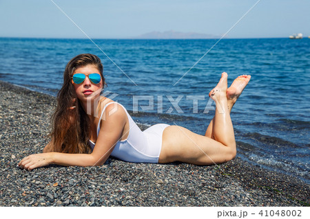 Woman sunbathing on the beach Woman sunbathing on the beach 41048002