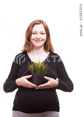Beautiful woman holding a pot with grass and smiling to the camera 41065854
