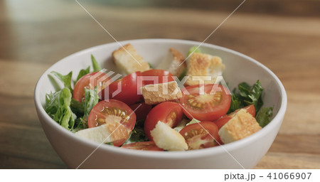 closeup adding croutons to caesar salad 41066907