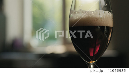 dark lager beer into a glass backlit by sunset light dark lager beer into a glass backlit by sunset light 41066986