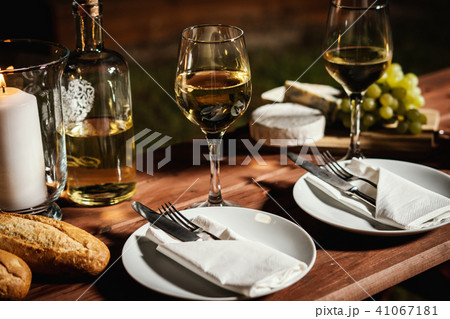 romantic dinner with a glass of wine and snacks on an old wooden table romantic dinner with a glass of wine and snacks on an old wooden table 41067181