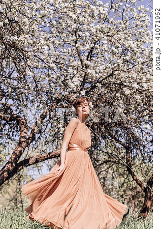 Girl in a pink dress is posing in a garden full  41071962