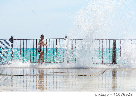 boy playing in the waves off the pier boy playing in the waves off the pier 41076928