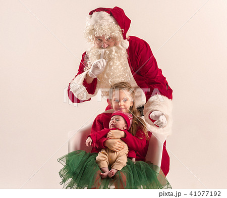 Christmas portrait of cute little newborn baby girl, dressed in christmas clothes, studio shot Christmas portrait of cute little newborn baby girl, dressed in christmas clothes, studio shot 41077192