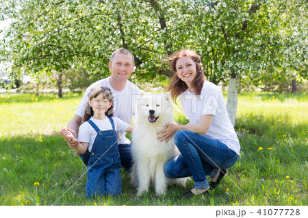 Happy family with a white dog in a summer park. 41077728